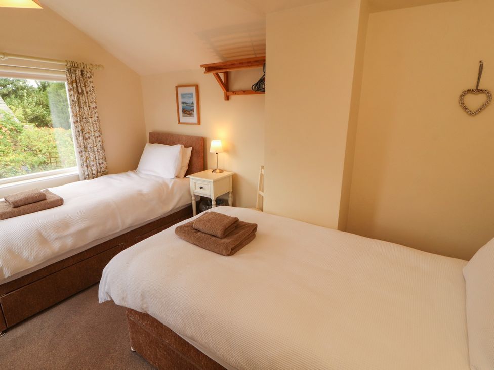 A bedroom with two beds and a nightstand at The Orchard in Levens