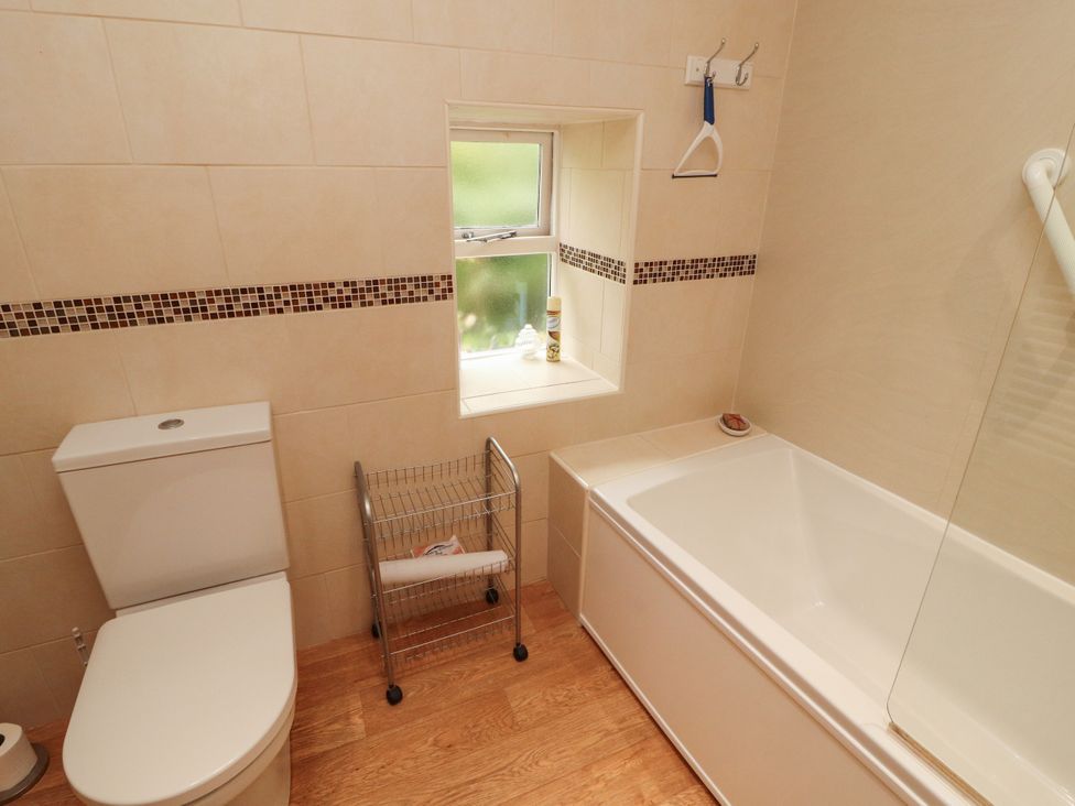 A bathroom with a toilet and bathtub at The Orchard in Levens