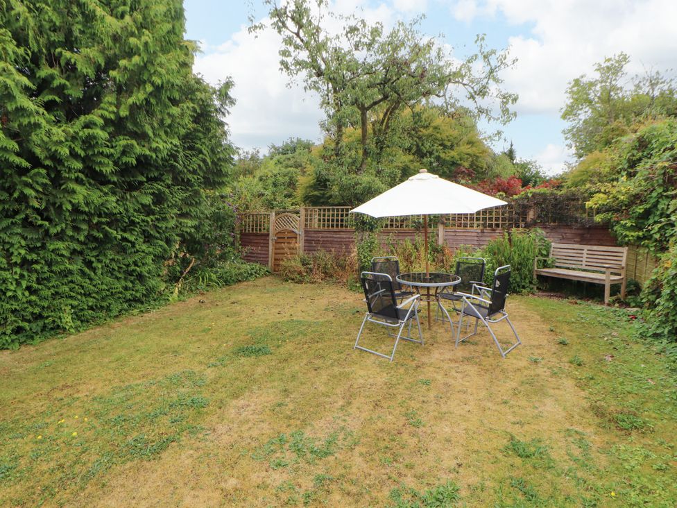 A garden with a table and chairs under an umbrella at The Orchard in Levens