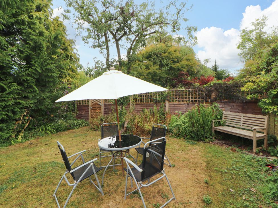 A garden with a table, chairs, and an umbrella at The Orchard in Levens