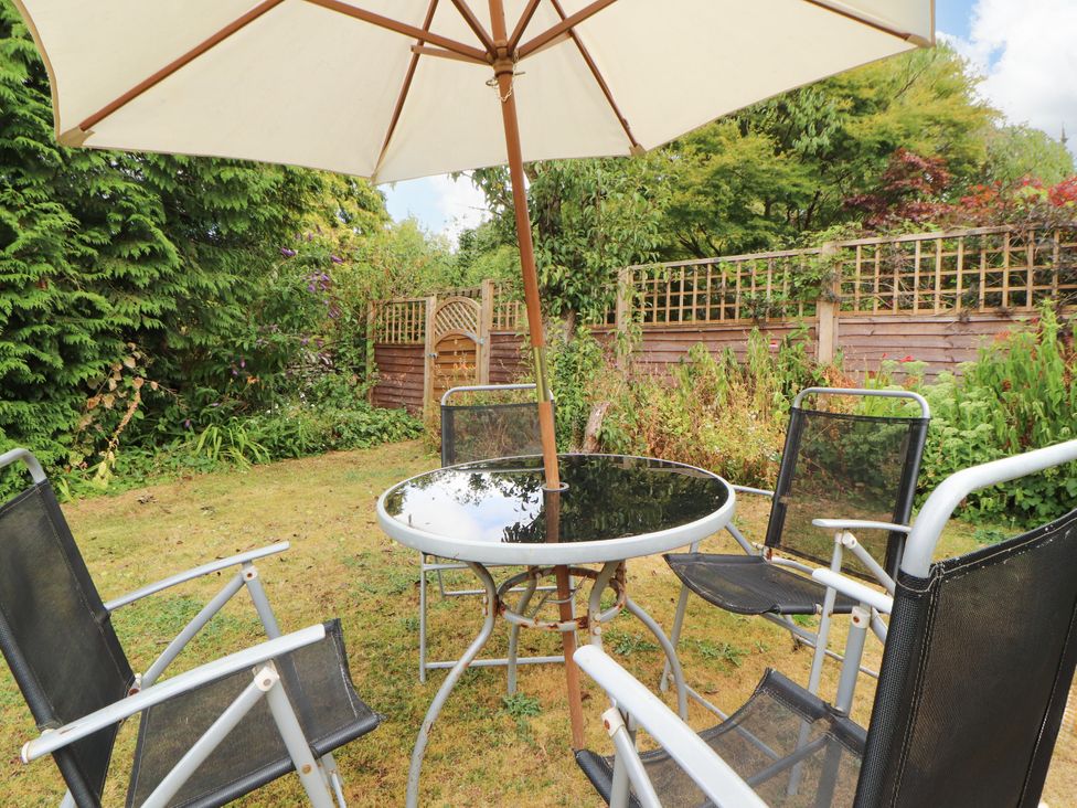 A garden with a table and chairs under an umbrella at The Orchard in Levens
