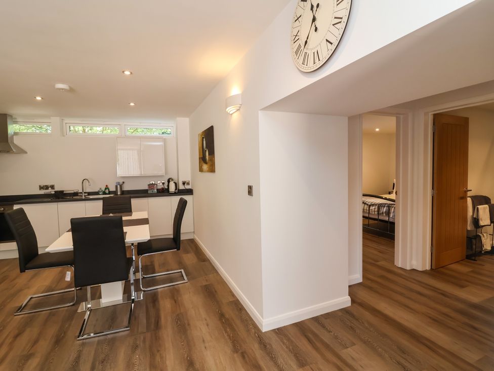 A kitchen with a dining area and doorway to a bedroom at Down Cottage in Zeal Monachorum