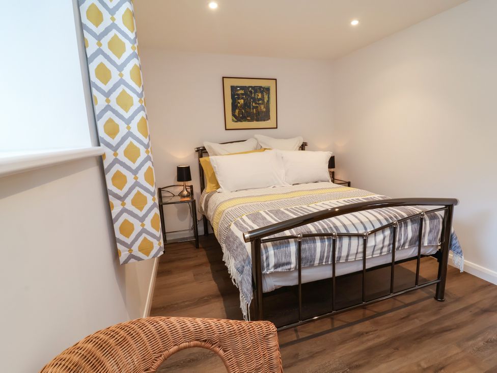 A bedroom with a bed and bedside table at Down Cottage Zeal Monachorum