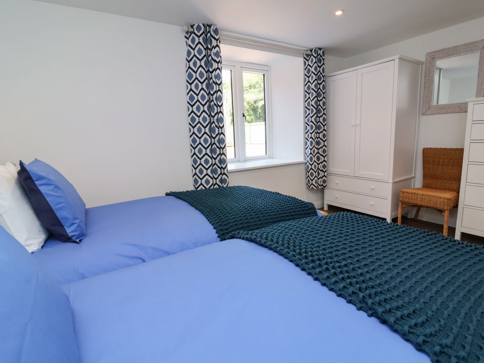 A bedroom with twin beds and a window at Down Cottage in Zeal Monachorum