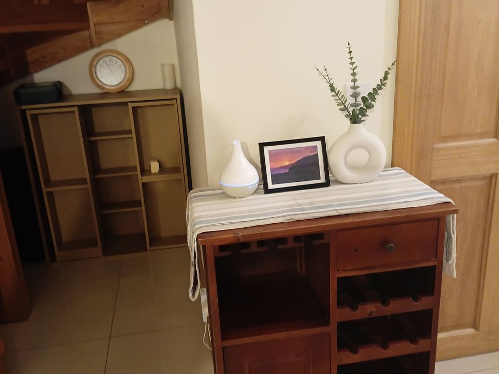 A dining table with a vase and photo at Sliabh League Mountain Lodge, TEILEANN near Kilcar, County Donegal