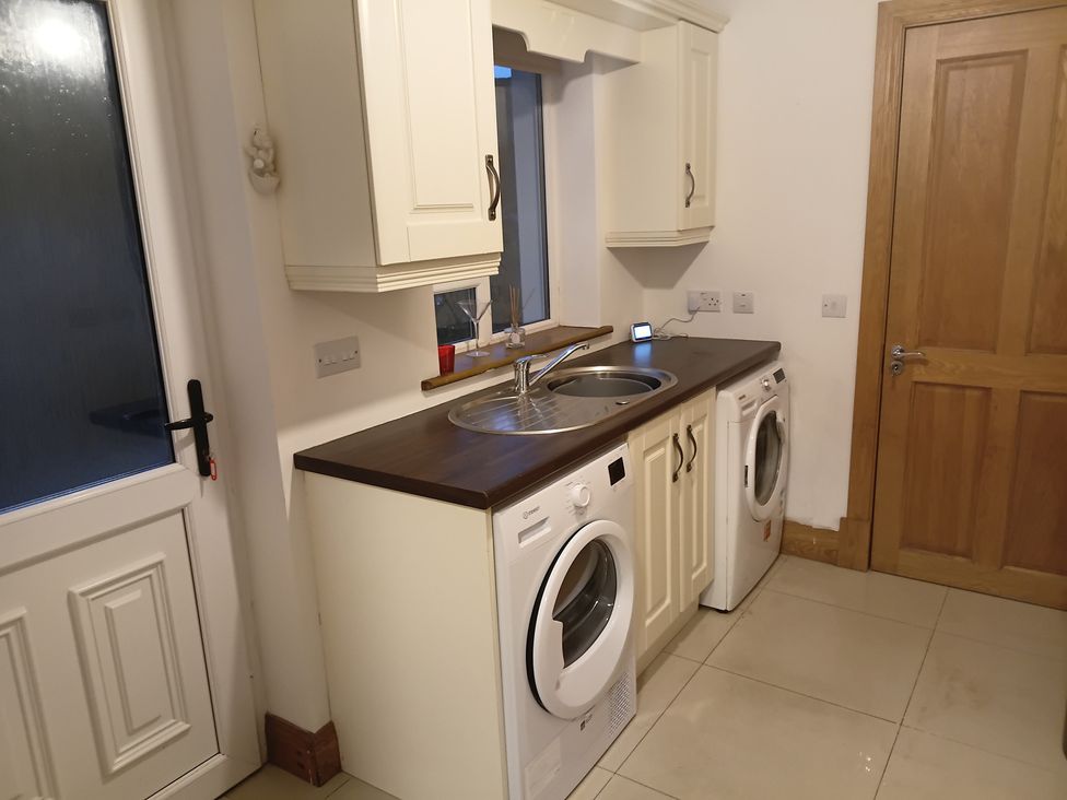 A laundry room with washing machines and a sink at Sliabh League Mountain Lodge TEILEANN near Kilcar, County Donegal