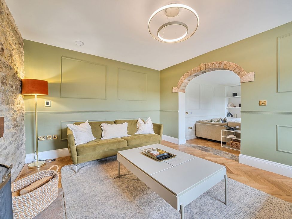 A living room with a sofa and coffee table at Hillside House in Leyburn
