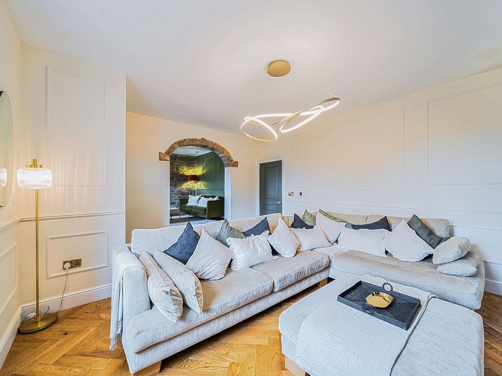 A living room with a sofa and lamp at Hillside House in Leyburn