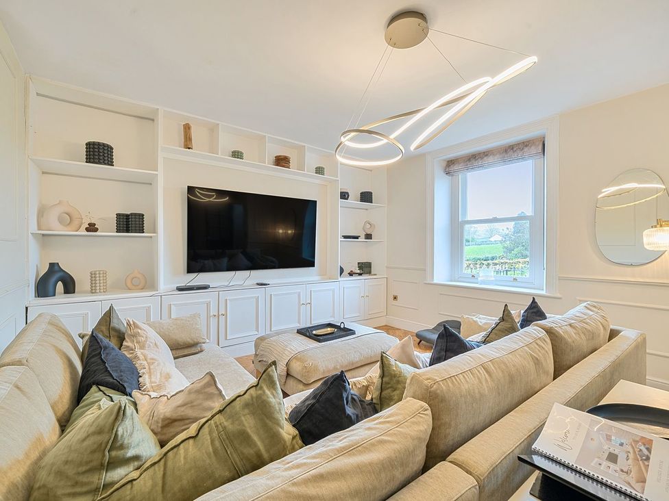 A living room with a television and shelves at Hillside House in Leyburn