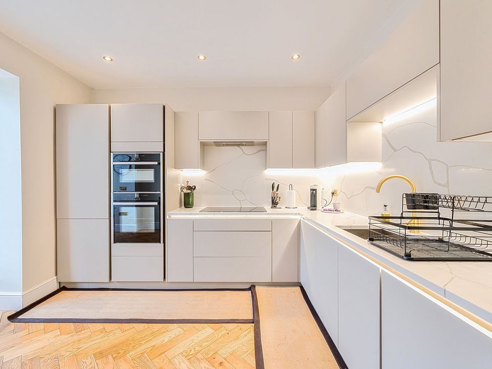 A kitchen with appliances and white cabinetry at Hillside House in Leyburn