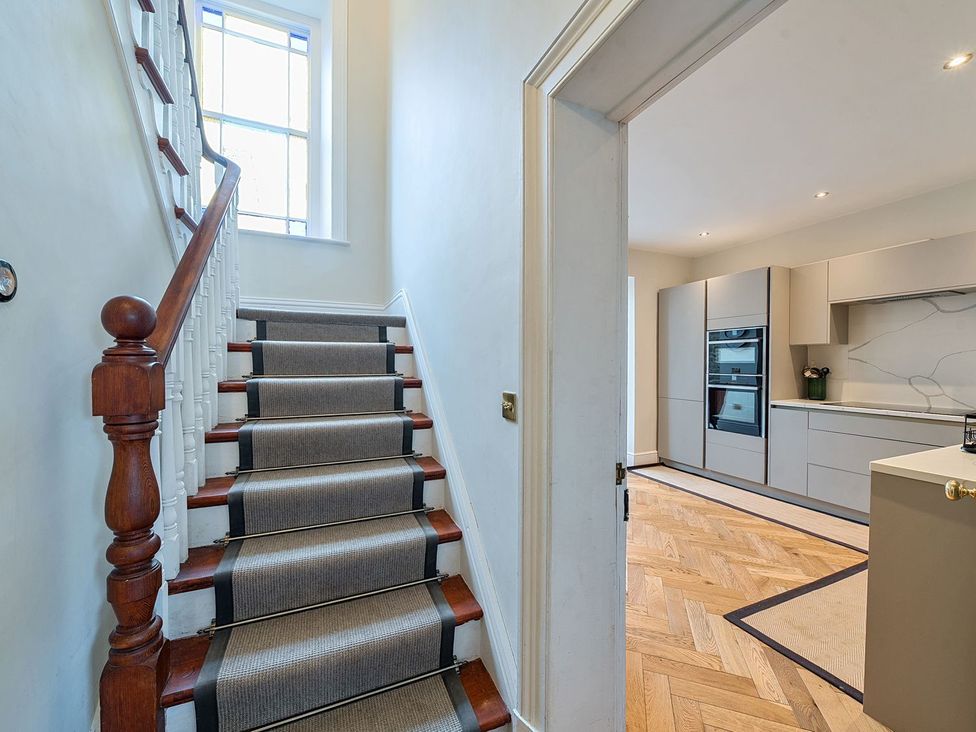 A hallway with a staircase leading to the upper floor at Hillside House in Leyburn