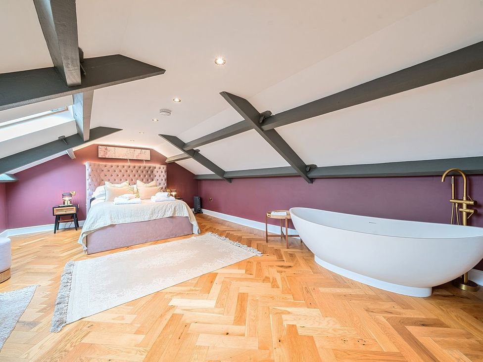 A bedroom with a bed and bathtub at Hillside House in Leyburn