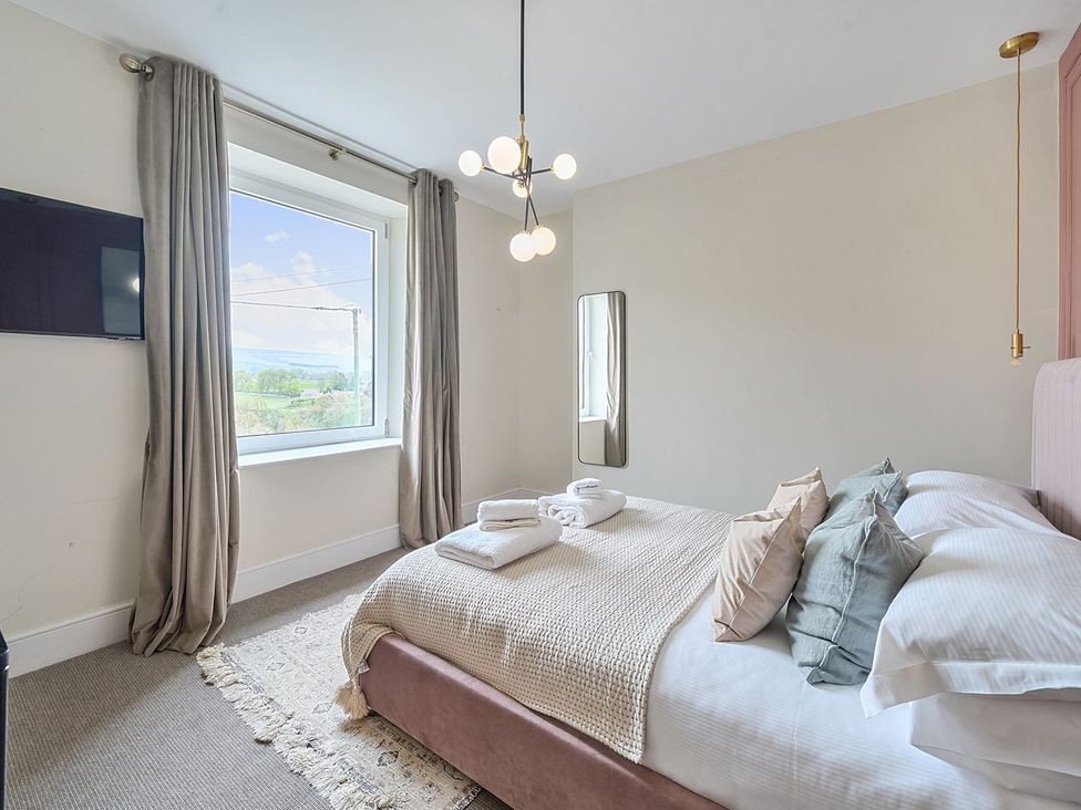 A bedroom with a bed and window at Hillside House in Leyburn
