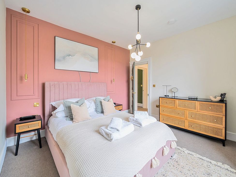 A bedroom with a bed and dresser at Hillside House Leyburn