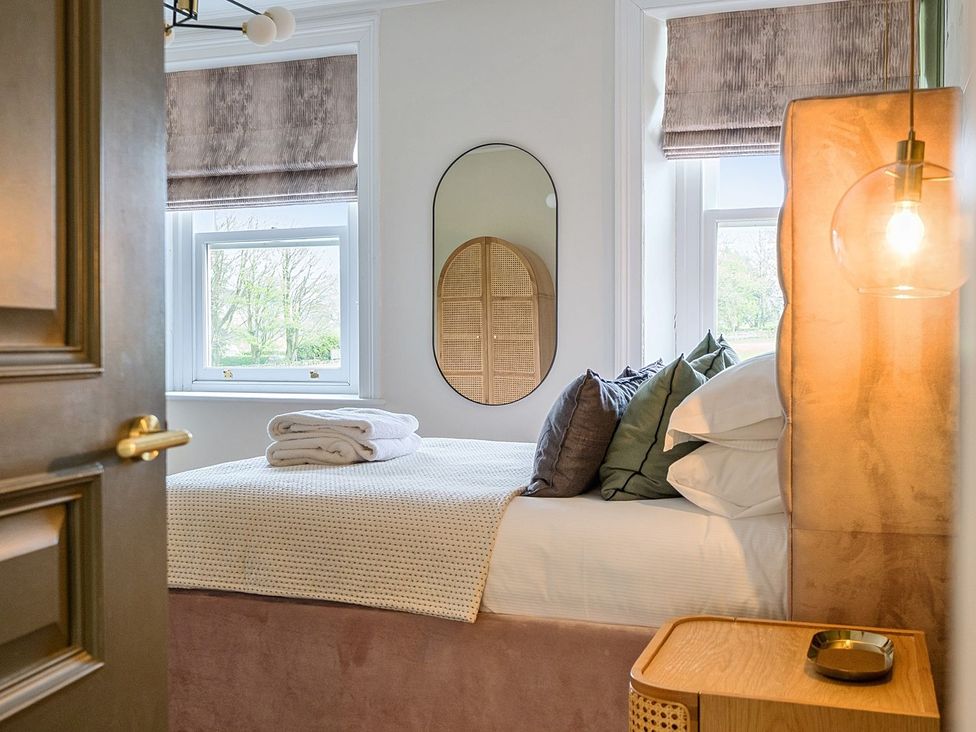 A bedroom with a bed, pillows, and towels at Hillside House in Leyburn