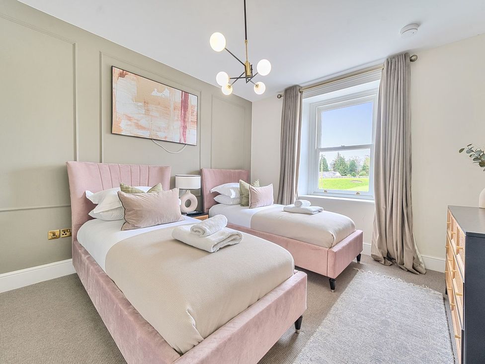 A bedroom with two beds and a window at Hillside House in Leyburn