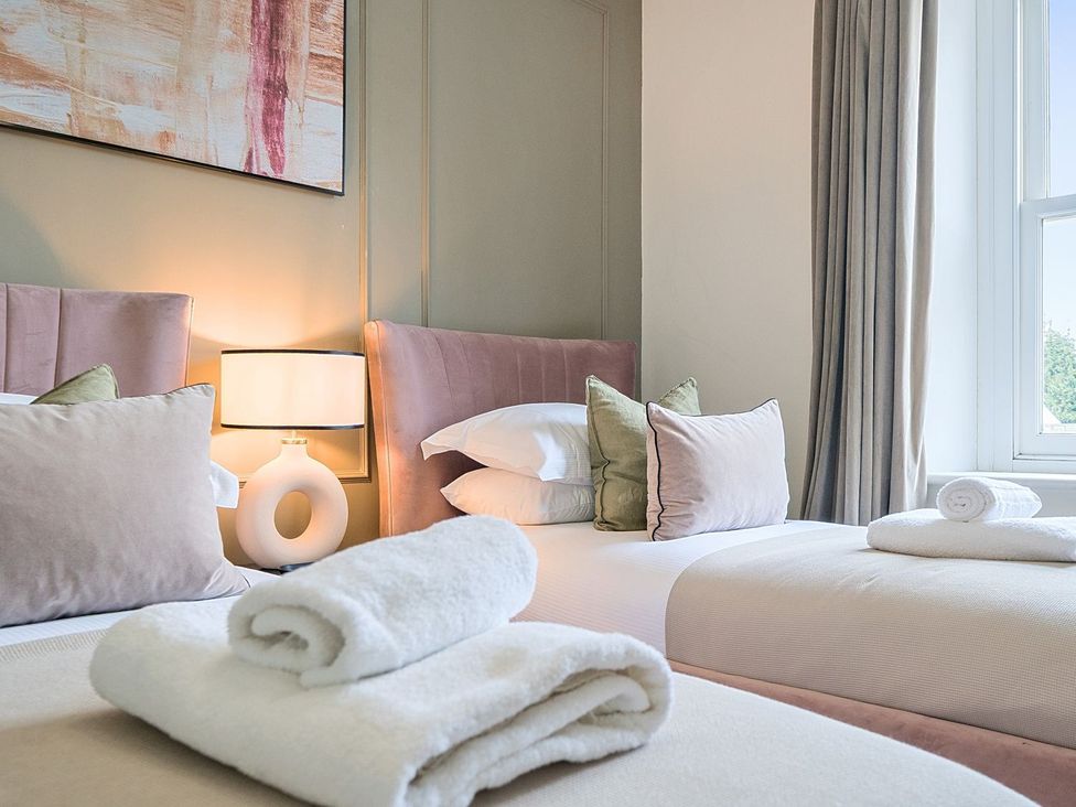 A bedroom with two beds and a lamp at Hillside House in Leyburn