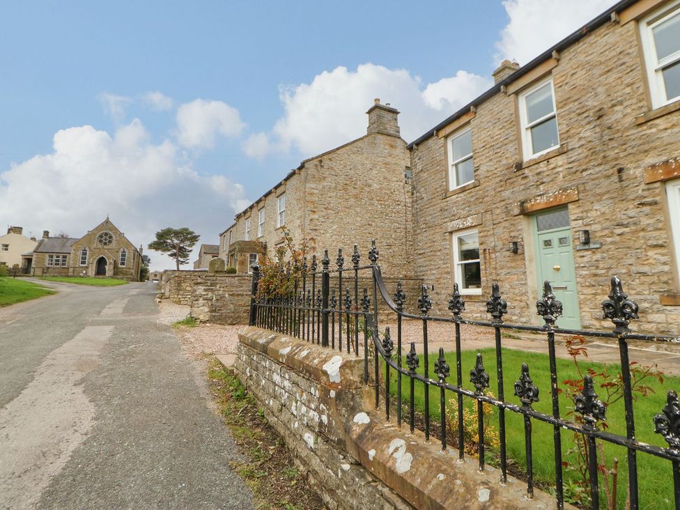 A house with a garden and fence at Hillside House in Leyburn