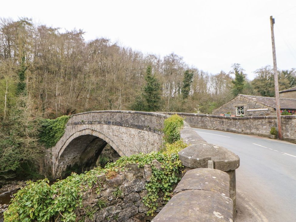 A bridge over a river with trees in the background at Hillside House Leyburn