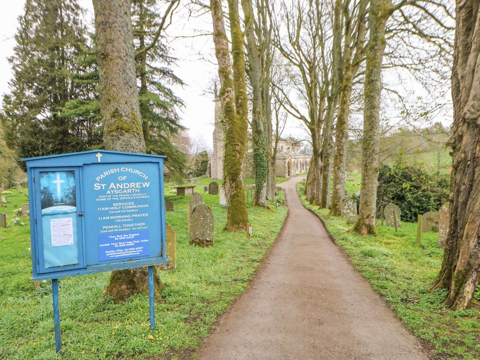 A pathway lined with trees leading to St Andrew Church in Aysgarth
