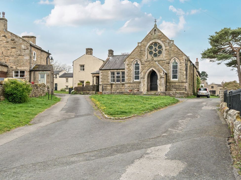 A church with houses and a road at Hillside House Leyburn