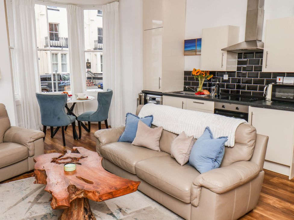 A living room with a dining table and kitchen area at Flat 1 in Whitby
