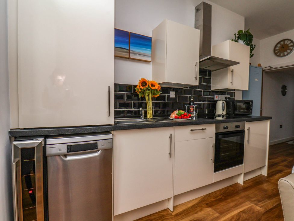A kitchen with appliances and flowers at Flat 1 in Whitby