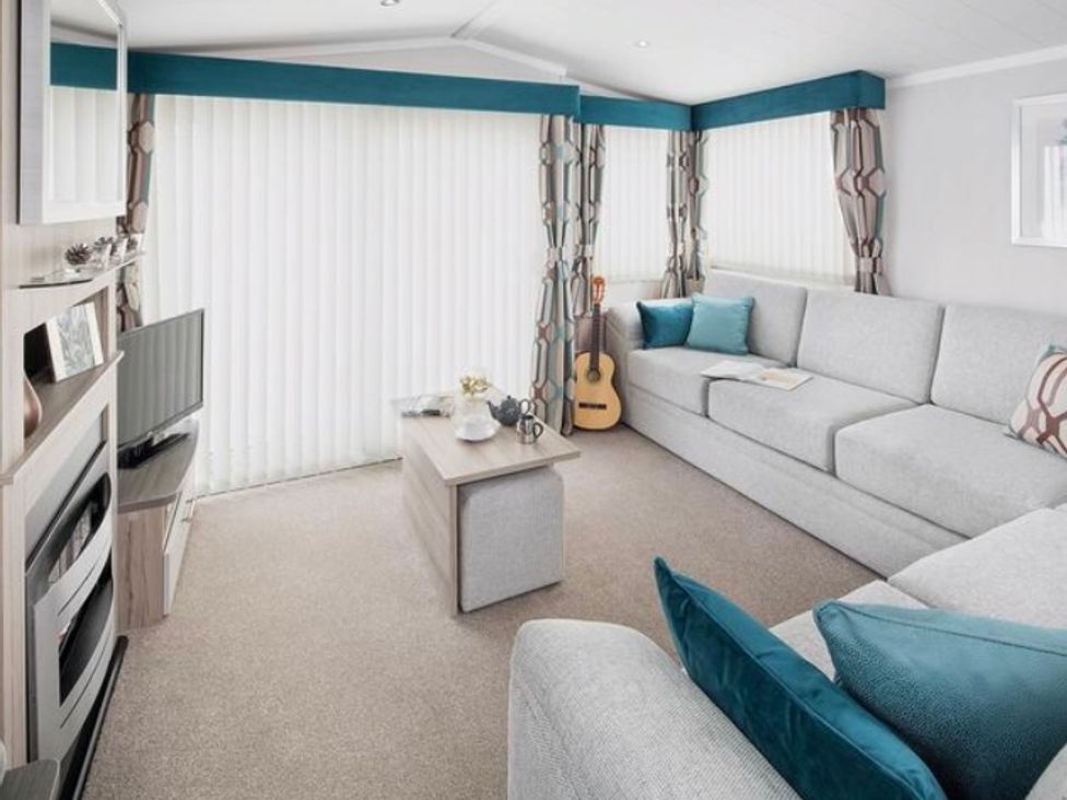A living room with a sofa and coffee table at Sandy beach retreat in Prestatyn