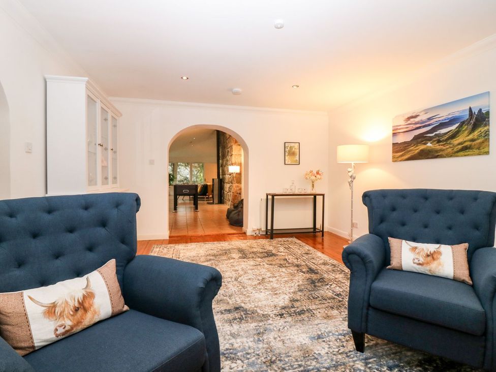 A living room with blue armchairs and a console table at Boat House in Aberdeen