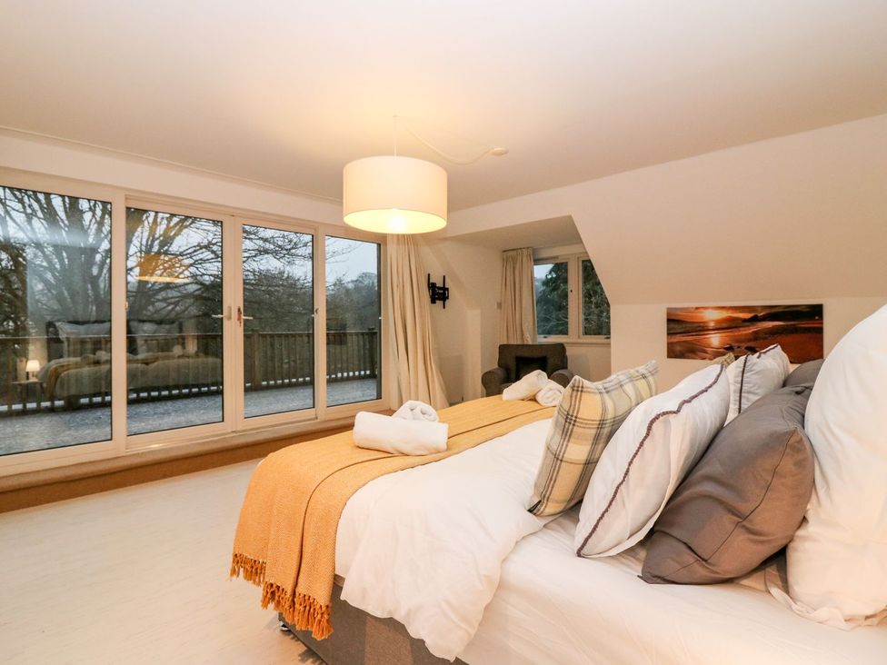 A bedroom with a bed and large windows at Boat House in Aberdeen