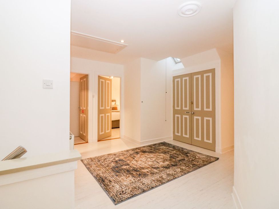 A hallway with doors and a rug at Boat House in Aberdeen