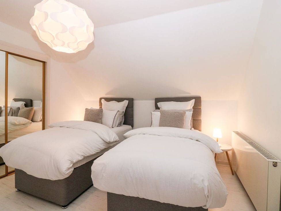 A bedroom with two beds and a lamp at Boat House in Aberdeen