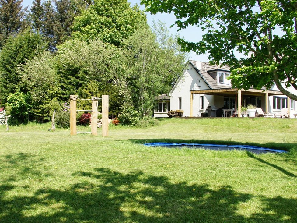 A garden with a house and trampoline at Boat House in Aberdeen