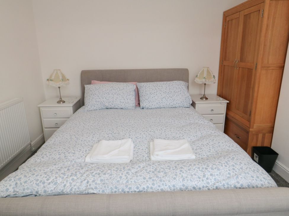 A bedroom with a bed, nightstands and wardrobe at 12 Neptune Terrace in Bridlington