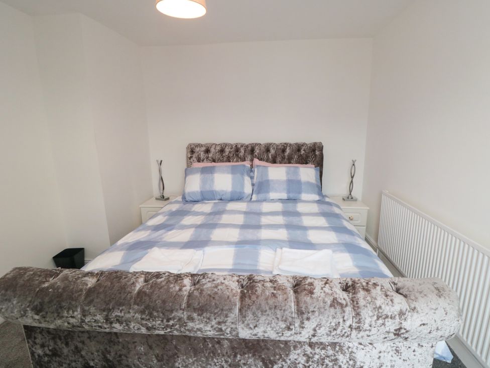 A bedroom with a large bed and bedside tables at 12 Neptune Terrace in Bridlington