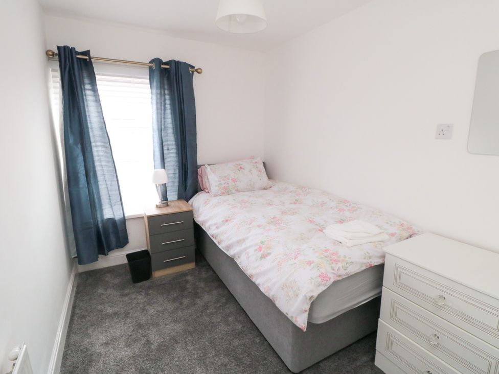A bedroom with a single bed and bedside table at 12 Neptune Terrace in Bridlington