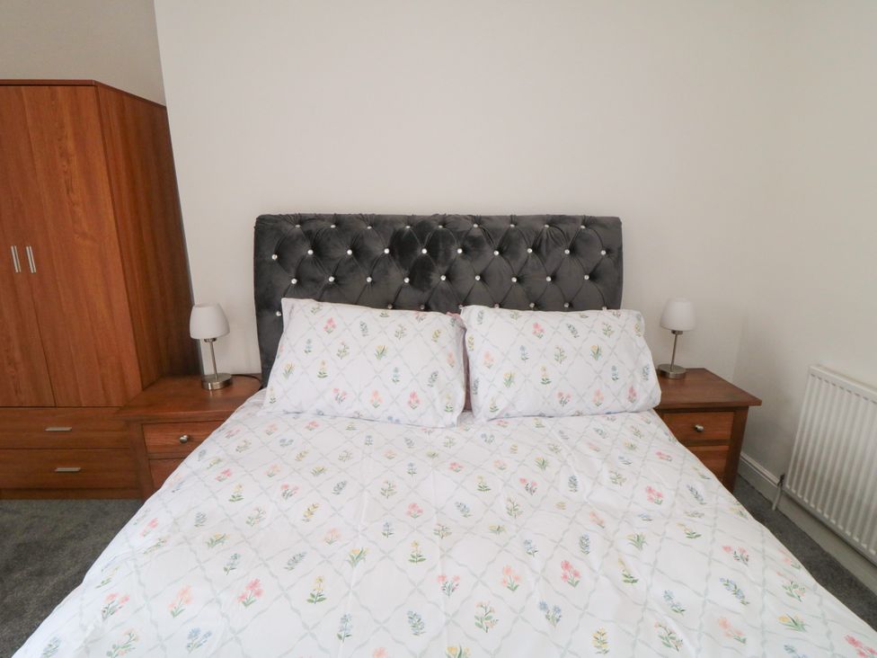 A bedroom with a bed and side tables at 12 Neptune Terrace in Bridlington