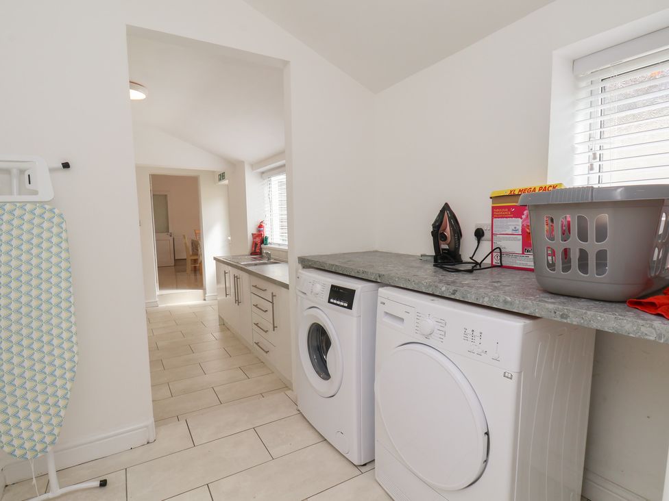 A laundry room with washing machine and countertop at K & J Holiday House in Bridlington