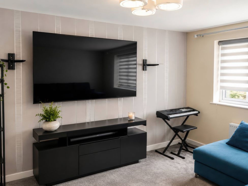 A living room with a television, TV stand, and keyboard at 4 Britannia Street Salford