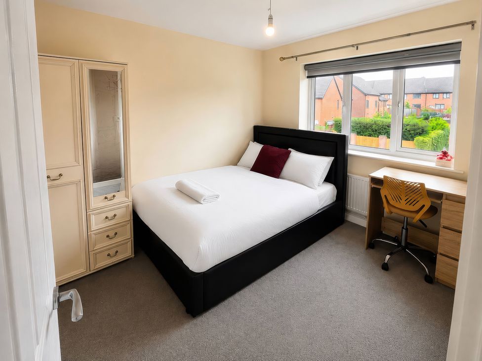 A bedroom with a bed and a desk at 4 Britannia Street in Salford