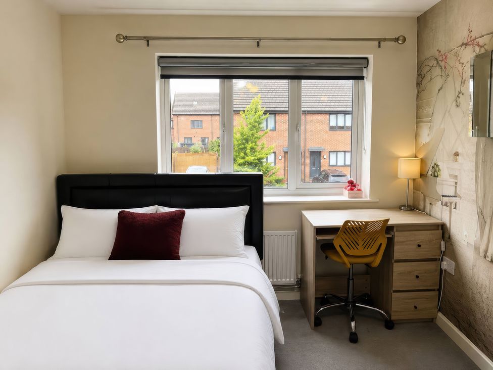 A bedroom with a bed and a desk at 4 Britannia Street, Salford