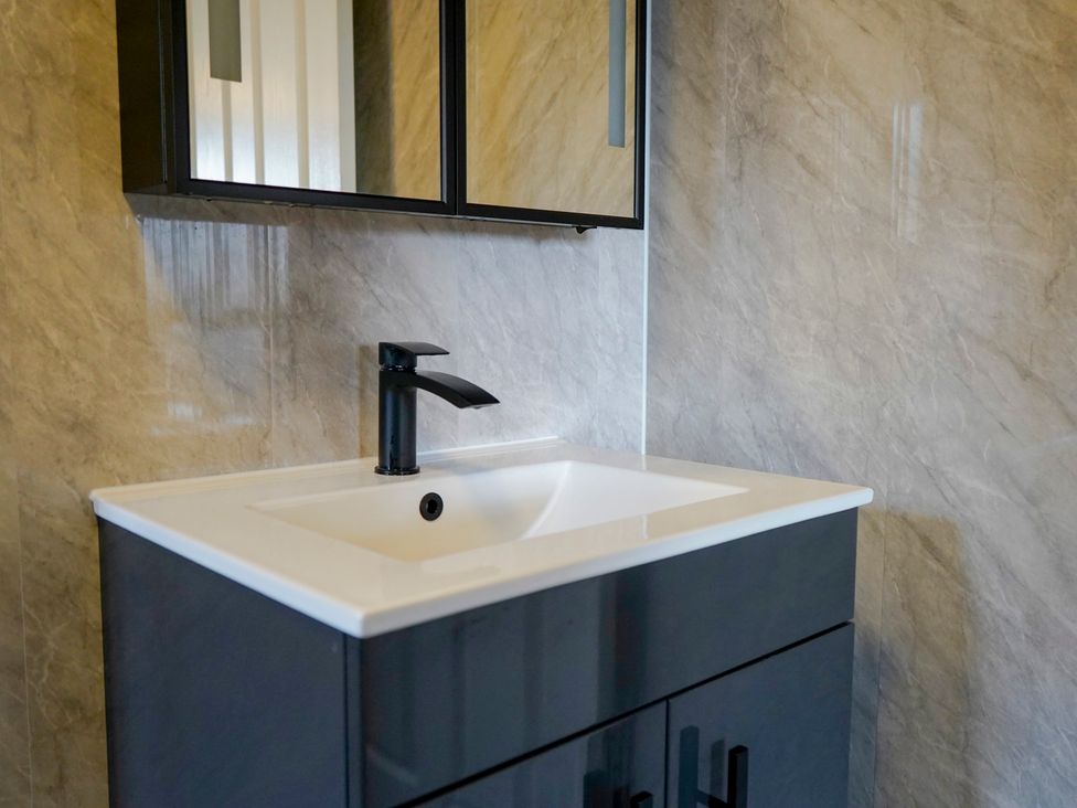 A sink with a faucet and mirror in a bathroom at 4 Britannia Street Salford