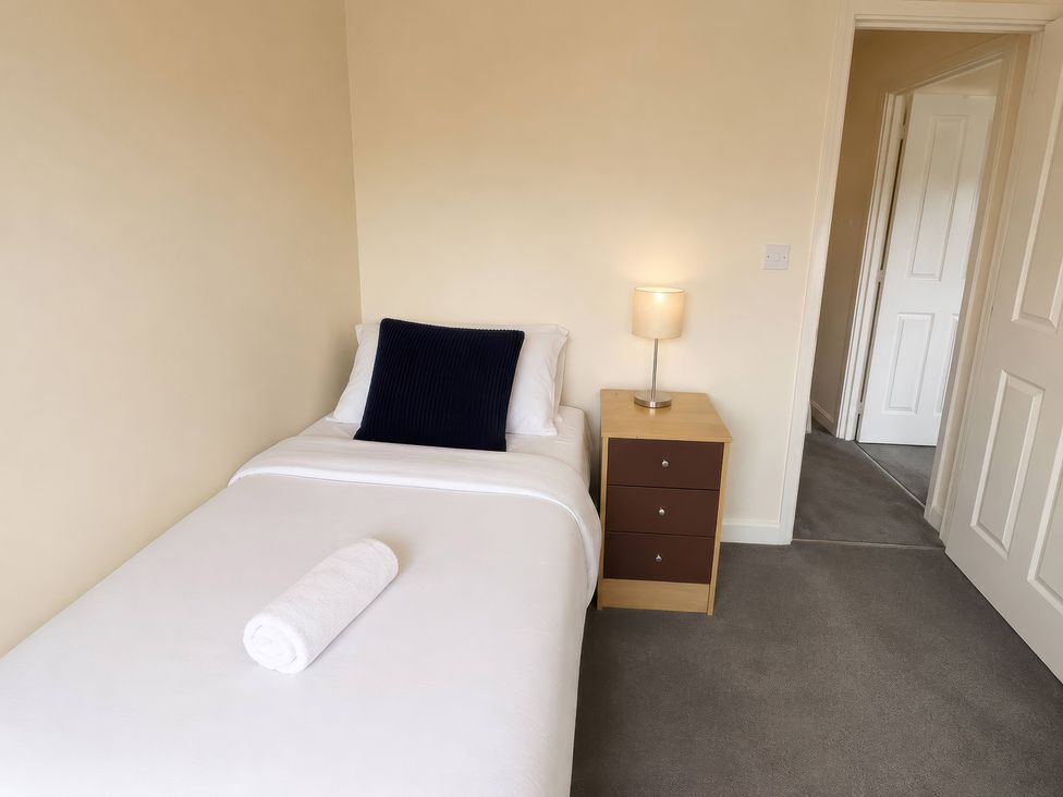 A bedroom with a single bed and nightstand at 4 Britannia Street in Salford