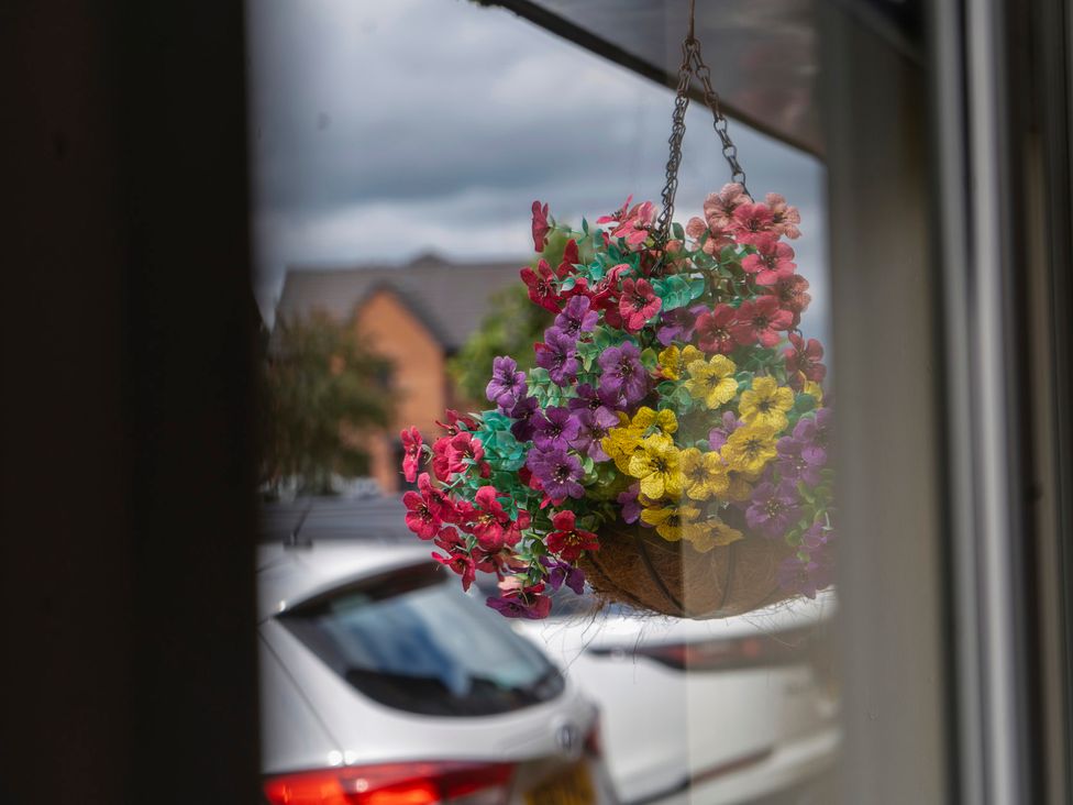 A hanging basket with flowers viewed from a window at 4 Britannia Street Salford