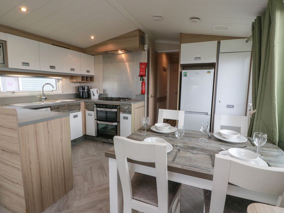 A kitchen with a dining table and chairs at 101 Bay View in Ayr