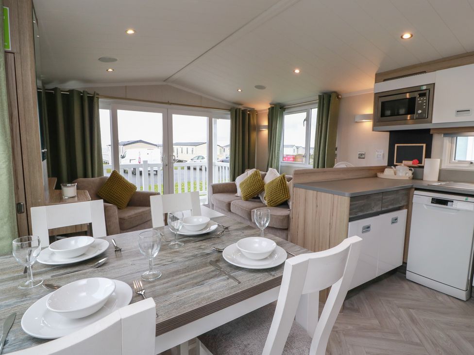 A living room with a dining table and seating area at 101 Bay View in Ayr