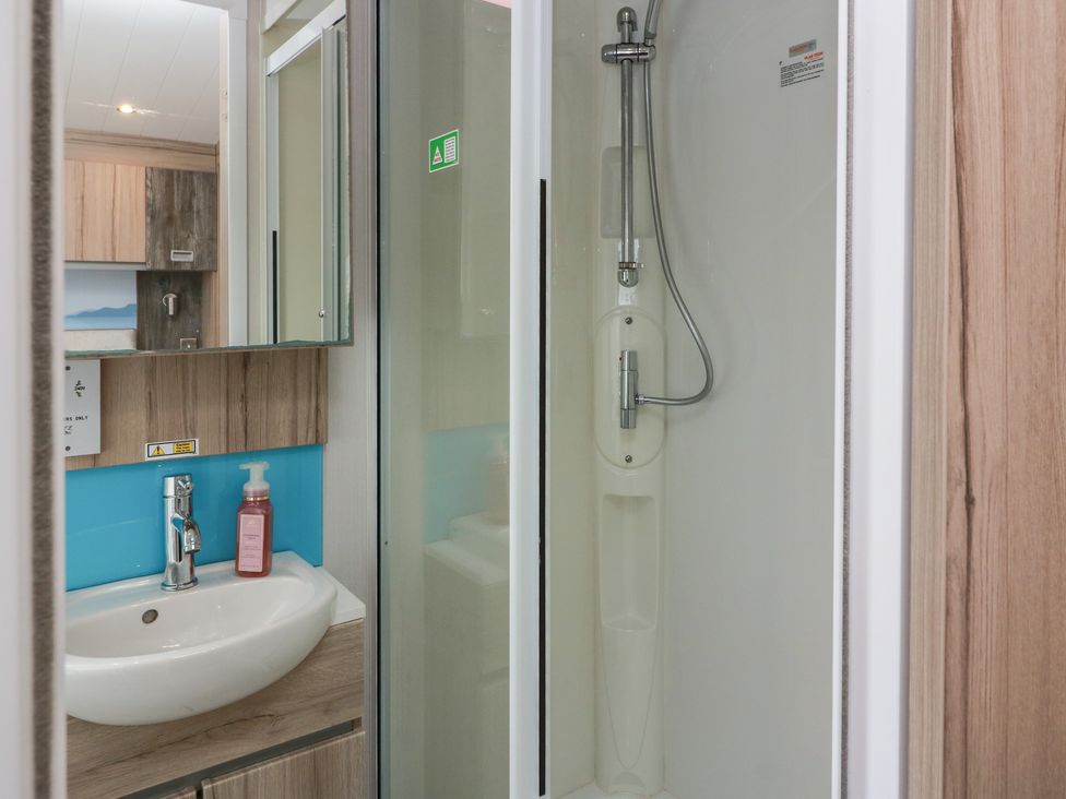 A bathroom with a sink and shower at 101 Bay View in Ayr