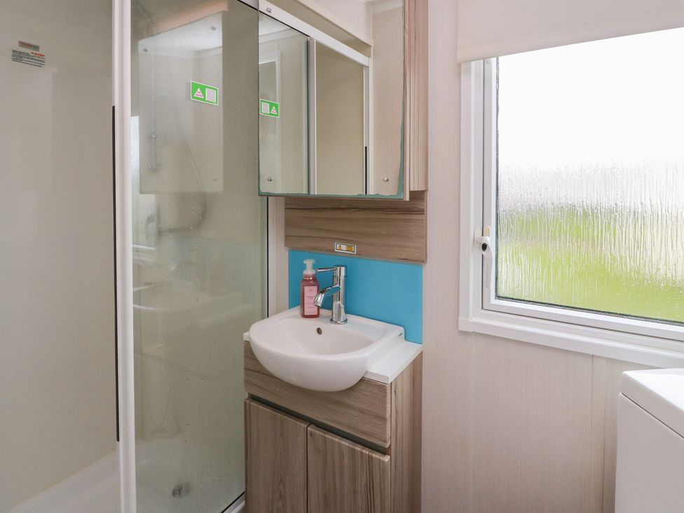A bathroom with a shower and sink at 101 Bay View in Ayr