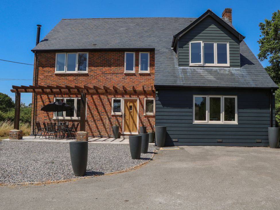 A house with patio furniture and planters at Perry Dees in Minstead
