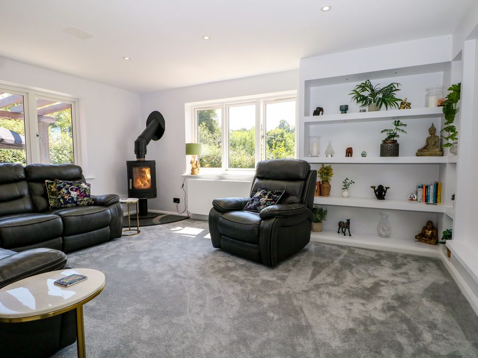 A living room with a stove and seating area at Perry Dees in Minstead